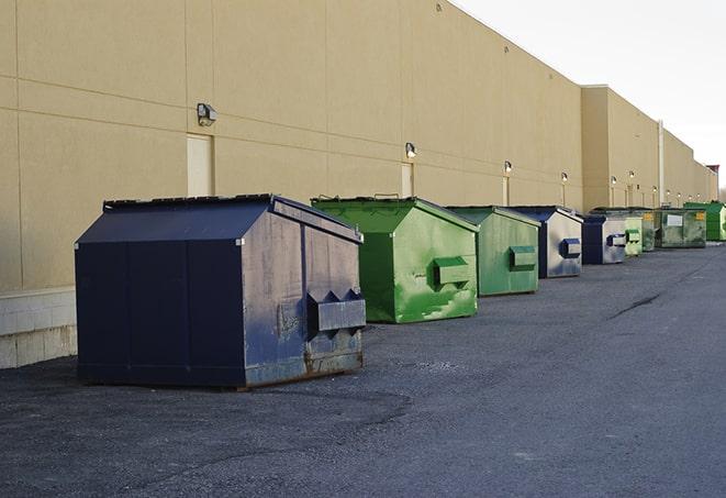 a construction worker disposing of debris into a dumpster in Camden, OH